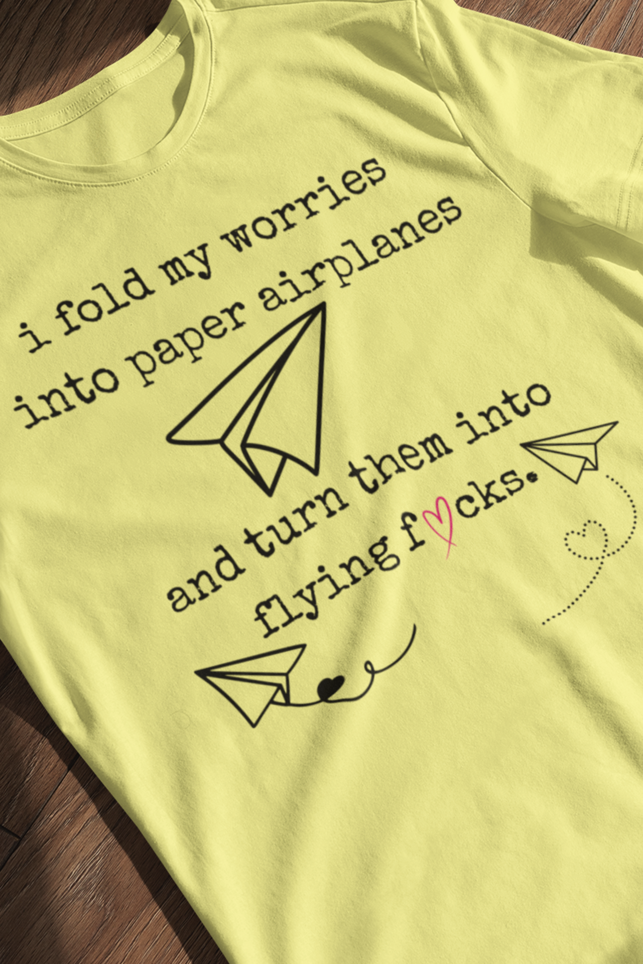 Women's adult humor t-shirt stating 'i fold my worries into paper airplanes and turn them into flying fucks' in color yellow