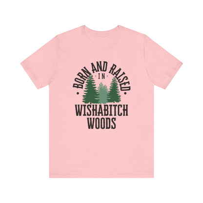 Comfortable adult humor tee stating Born and Raised in Wishab*tch Woods in color pink