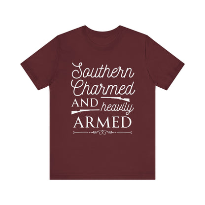 Adult unisex t-shirt stating 'Southern Charmed and Heavily Armed' in color maroon