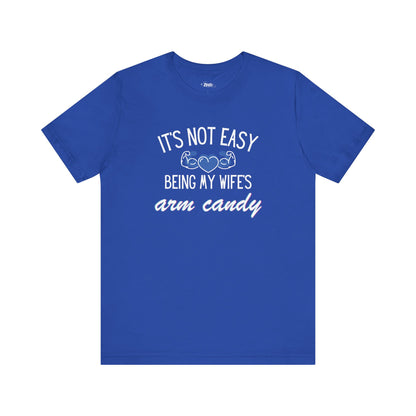 Graphic tee stating It's Not Easy Being My Wife's Arm Candy in color true royal