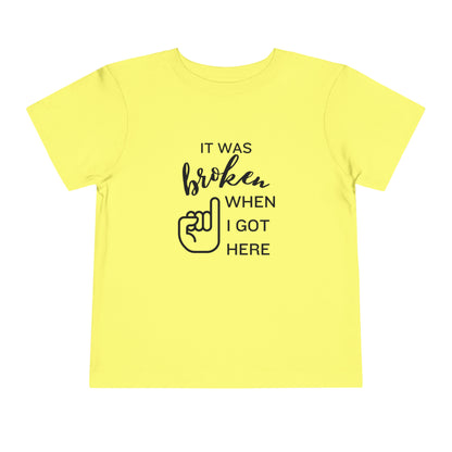Comfortable funny graphic toddler tee stating 'It was broken when I got here' in color yellow