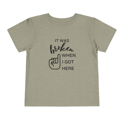 Comfortable funny graphic toddler tee stating 'It was broken when I got here' in color stone heather