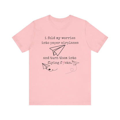 Women's adult humor t-shirt stating 'i fold my worries into paper airplanes and turn them into flying fucks' in color pink