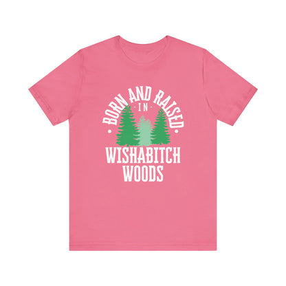 Comfortable adult humor tee stating Born and Raised in Wishab*tch Woods in color charity pink