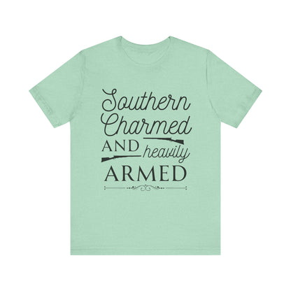 Adult unisex t-shirt stating 'Southern Charmed and Heavily Armed' in color mint heather