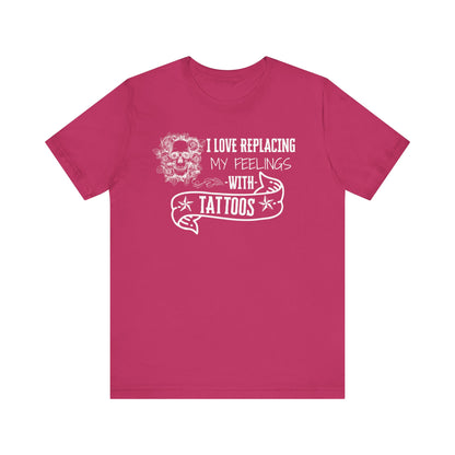 A sarcastic graphic tee stating 'I love replacing my feelings with tattoos' in color berry
