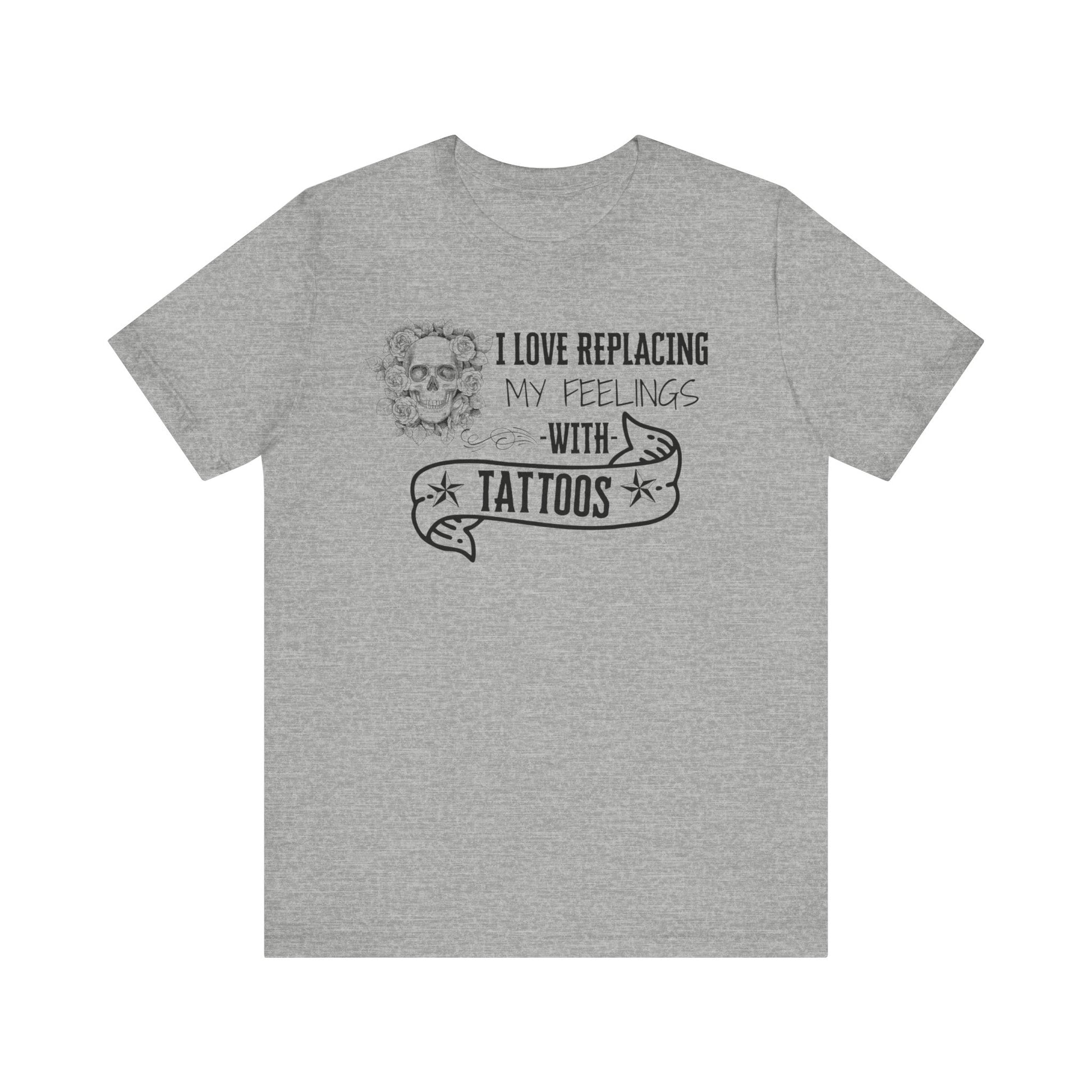 A sarcastic graphic tee stating 'I love replacing my feelings with tattoos' in color athletic heather