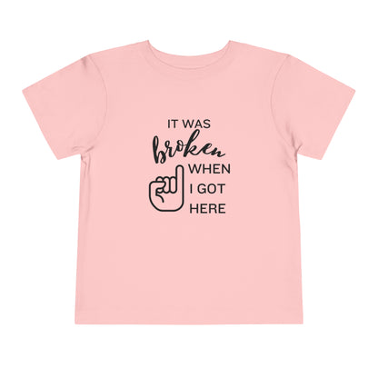 Comfortable funny graphic toddler tee stating 'It was broken when I got here' in color pink