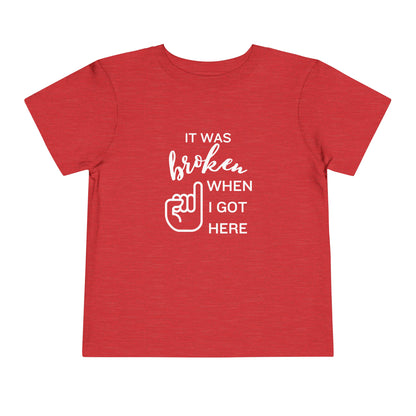 Comfortable funny graphic toddler tee stating 'It was broken when I got here' in color heather red