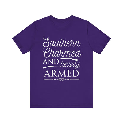 Adult unisex t-shirt stating 'Southern Charmed and Heavily Armed' in color team purple
