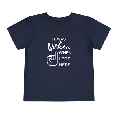 Comfortable funny graphic toddler tee stating 'It was broken when I got here' in color navy
