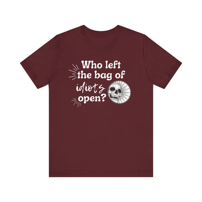 Unisex graphic tee stating 'Who left the bag of idiots open?' in color maroon