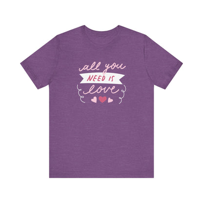 Comfortable Women's Graphic Tee Stating 'All You Need Is Love' in color heather purple