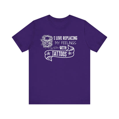 A sarcastic graphic tee stating 'I love replacing my feelings with tattoos' in color purple
