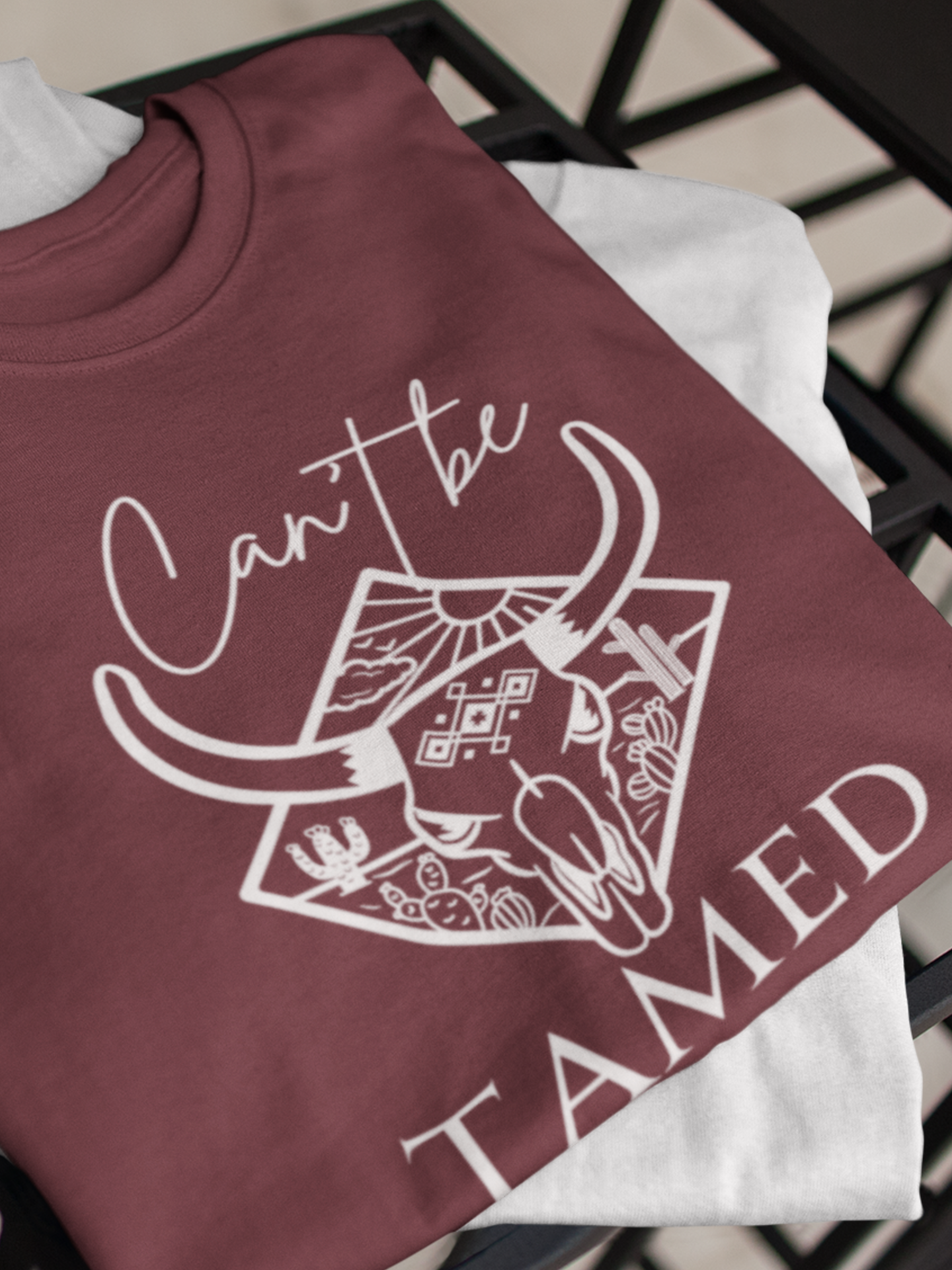 Comfortable Unisex T-Shirt stating 'Can't Be Tamed' in color maroon