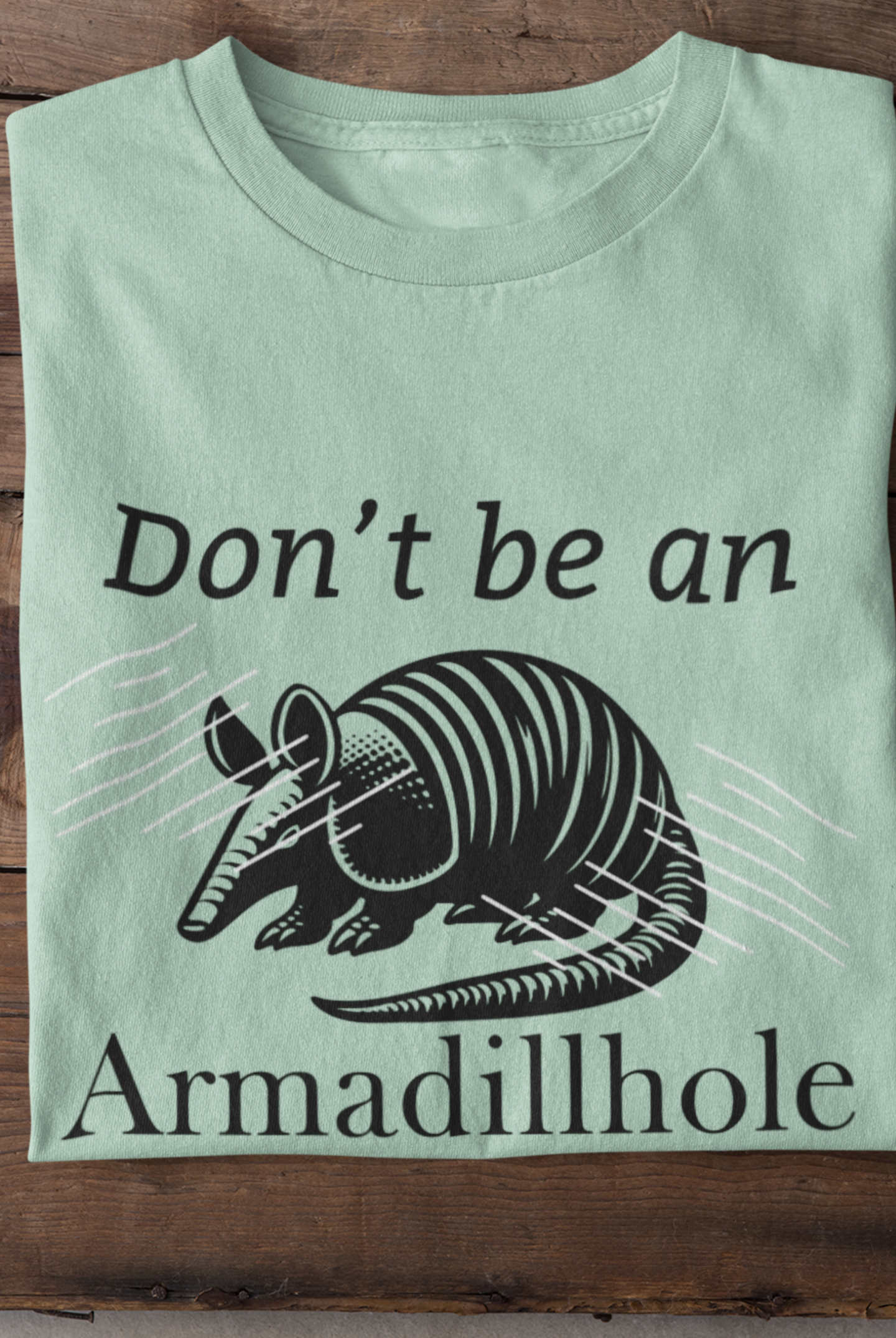Unisex t-shirt stating 'Don't be an Armadillhole' in color mint heather