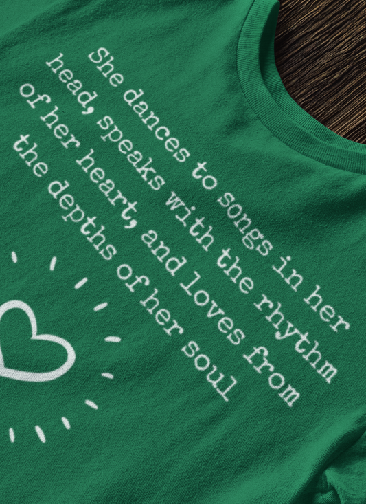 Comfortable good vibes graphic t-shirt stating 'She dances to songs in her head, speaks with the rhythm of her heart, and loves from the depths of her soul' in color kelly