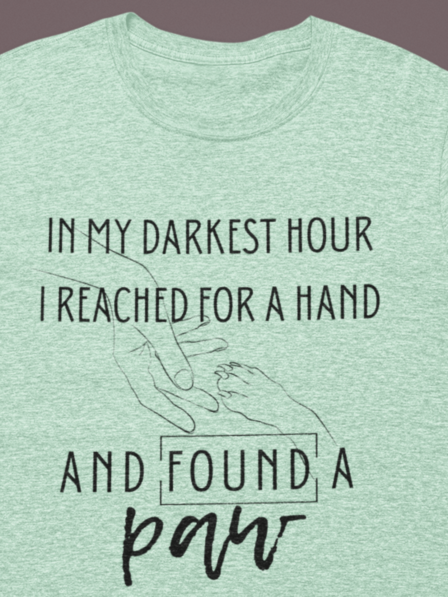 Comfortable graphic tee stating 'In my darkest hour I reached for a hand and found a paw' in color mint heather