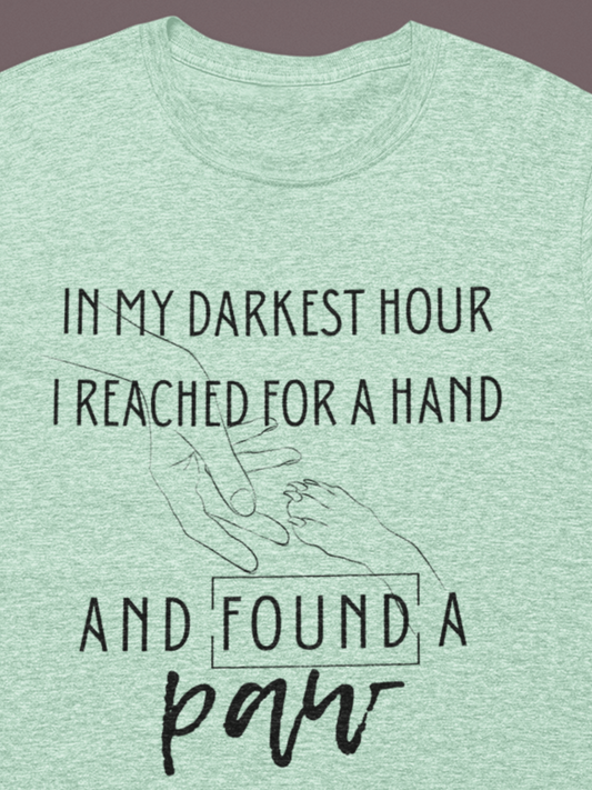 Comfortable graphic tee stating 'In my darkest hour I reached for a hand and found a paw' in color mint heather