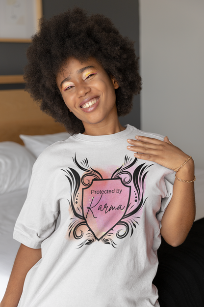 Woman with beautiful afro and smile wearing graphic tee stating Protected By Karma in color white