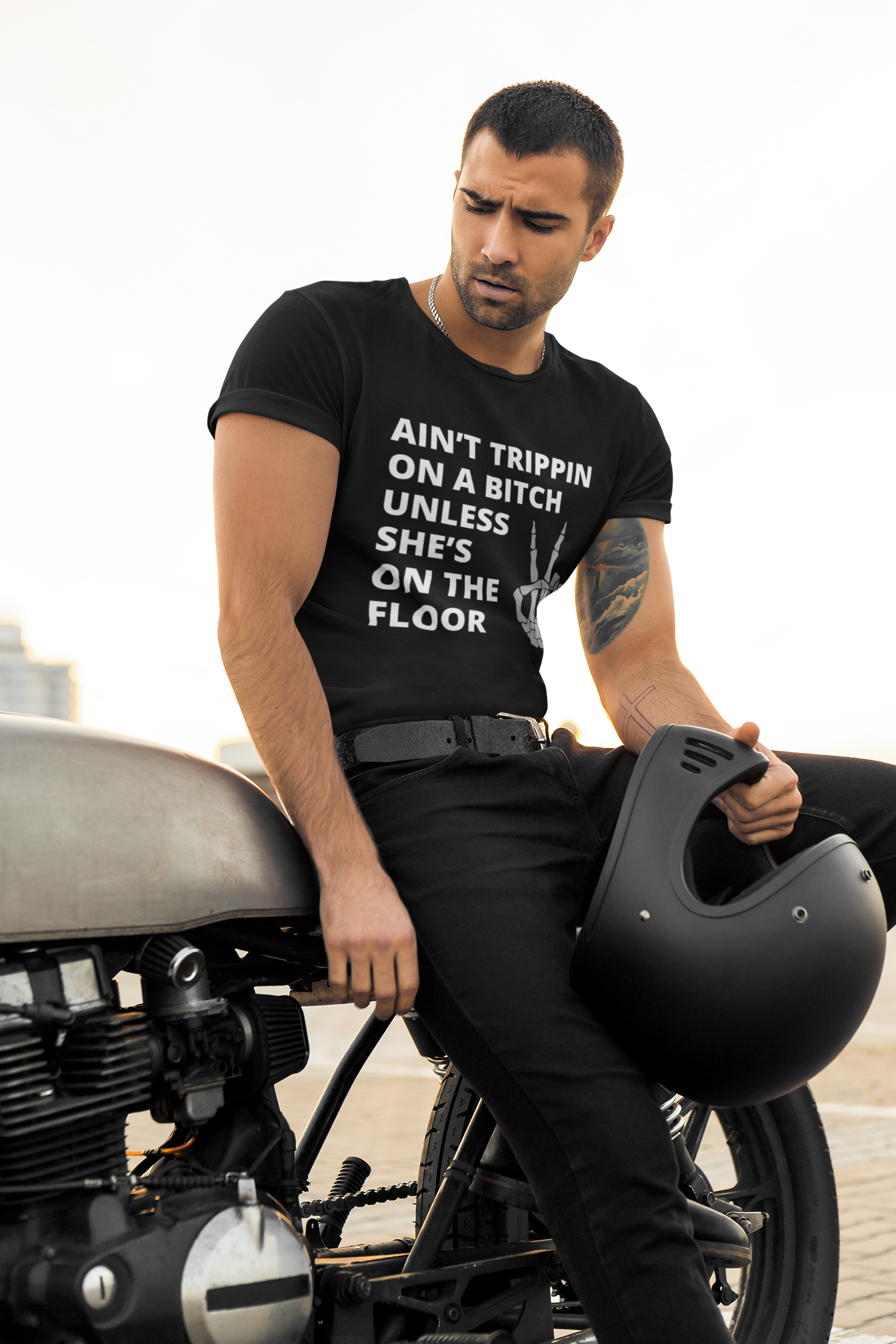 Man on motorcycle wearing Adult Humor Graphic T-Shirt stating Ain't Trippin On a Bitch Unless She's On the Floor in color 